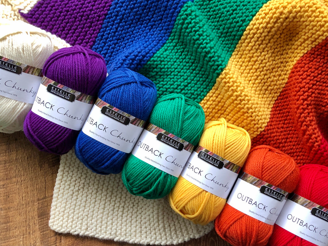 Chunky Rainbow yarn lying on rainbow knitted blanket